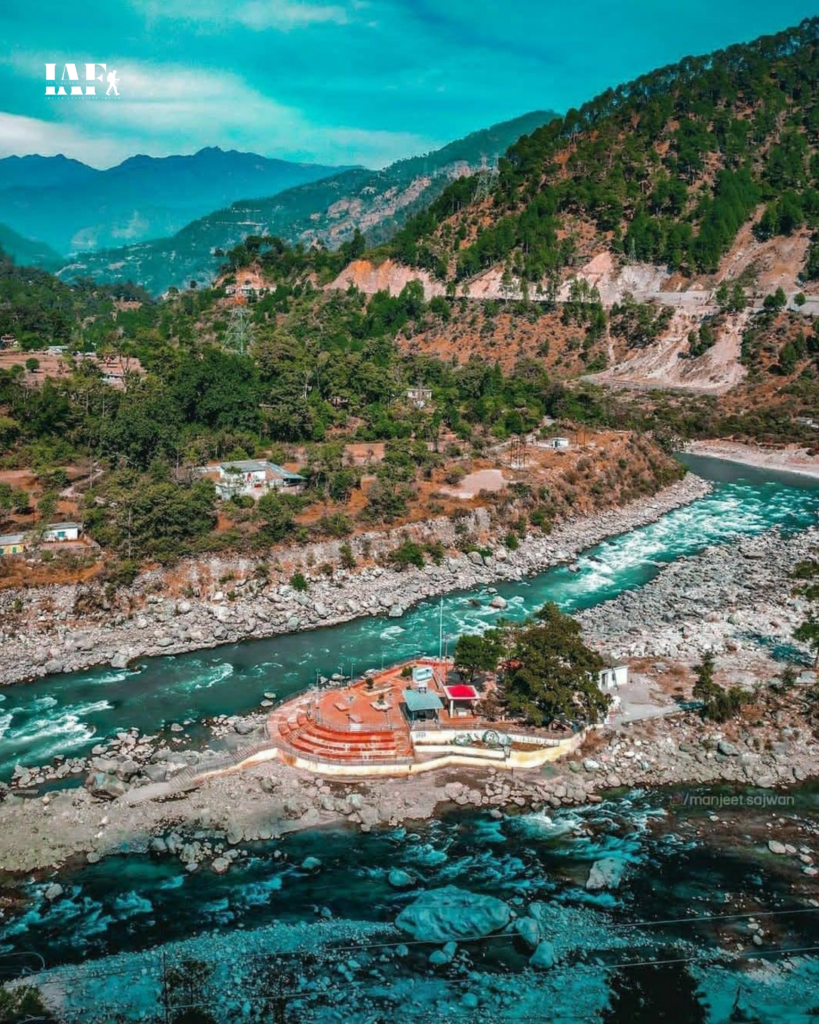 Aerial view of Nandprayag Sangam and ghat surrounded by mountains in Uttarakhand.